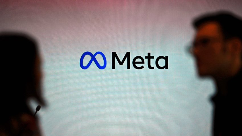 Visitors stand in front of a Meta logo during a launch event at the corporate offices of Meta in Berlin, June 6, 2023.